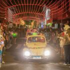 Carro decorado desfila com pessoas nas calçadas assistindo