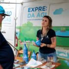 Mulher conversa com morador e explica sobre saneamento