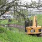 Máquina trabalha dentro de rio para retirada de resíduos