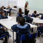 Professora conversa com alunos em sala de aula