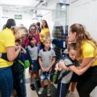 Professores abraçam alunos que chegam à escola