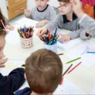 Crianças da educação infantil usam lápis de cor para desenhar
