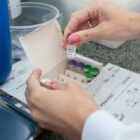 Profissional de saúde manipula frascos com vacina contra a dengue