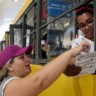Agente oferece informativo sobre dengue para mulher dentro de ônibus