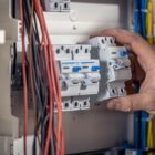 Homem manuseia caixa de disjuntor elétrico