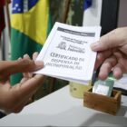 Pessoa entrega para outra um papel de dispensa militar