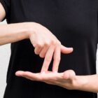 Pessoa usa língua de sinais com as mãos, Libras