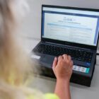 Mulher loira olha para tela de computador na página da transparência