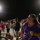 Pessoas em grupo em pé sorriem e olham para nova iluminação acesa
