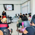 Agente da dengue fala para pessoas no auditório