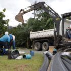 Homens trabalham com tubulação e máquinas