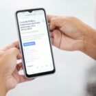 Pessoa segura celular nas mãos e na tela está a página para participar das consultas