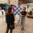 Mulher de óculos conversa com outra que está de costas em área montada pelo Procon no shopping
