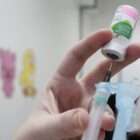 Profissional segura seringa e frasco com imunizante