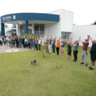 Pessoas de mãos dadas para cima na frente da sede do Centrinho