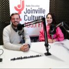 Um homem e uma mulher em um estúdio de rádio, com microfones