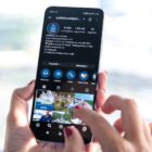 Mulher segura celular e navega no Instagram da Prefeitura de Joinville