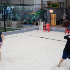 Uma mulher e um homem de meia idade jogam beach tennis