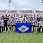 Time de futebol posa para foto em gramado