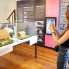 Duas mulheres fotografam exposição de peças em museu