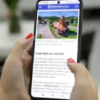 Pessoa segura celular nas mãos e na tela está a página do site Melhores Destinos