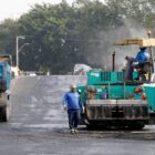 Trabalhadores com maquinário pavimentam a ponte