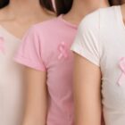 Mulheres com laços rosa nas camisetas