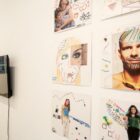 Parede de galeria com gravuras e desenhos expostos