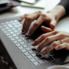 Mãos de mulher digitam em teclado de computador