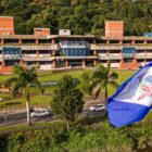 Fotografia da sede da Prefeitura com a bandeira de Joinville na frente