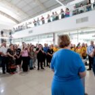 Prefeito e secretária em pé falam para plateia em frente