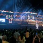 Fachada da Prefeitura com muito público acompanhando espetáculo de Natal com luzes e apresentações