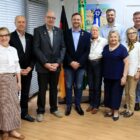 Doze pessoas posam para foto no gabinete do Prefeito