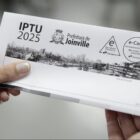 Mãos de mulher seguram carnê de IPTU
