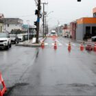 Rua pavimentada, em uma pista há carros e na outra cones indicando interdição da faixa