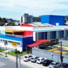 Imagem aérea de um novo Centro de Educação Infantil, uma construção grande, com detalhes em azul, amarelo e vermelho