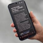 Pessoa segura celular, na tela uma mensagem falsa do Procon Brasil