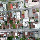Imagem aérea de ruas de Joinville, com casas e carros trafegando