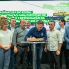 Prefeito assina documento observado por outras autoridades