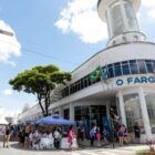 Fachada do prédio antigo, onde funcionou a Prefeitura, com rua ao lado fechada com barracas e pedestres circulando
