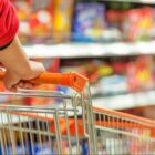 Pessoa empurra carrinho de compras em mercado
