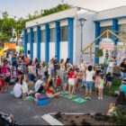 Crianças reunidas em uma praça acompanham apresentação de teatro com tema da Páscoa