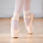 Pés de bailarina em sapatilha fazem passo para cima