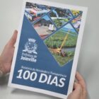 Pessoa segura relatório encadernado em mãos