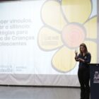 Duas mulheres em palco na frente de um telão
