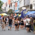 Feira de rua com barracas e pessoas circulando