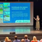 Mulheres em palco apresentam conteúdo em um telão