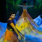 Espetáculo de teatro e dança com mulheres usando tecidos em palco