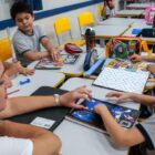 Professora acompanha atividade de alunos em sala de aula