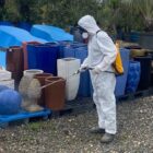 Homem com roupa especial e máscara aplica produto em vasos para eliminar mosquito da dengue